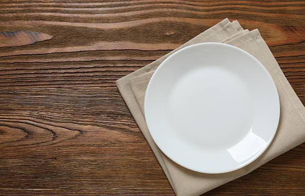 istock White empty plate with napkin on a wooden background 2249265446