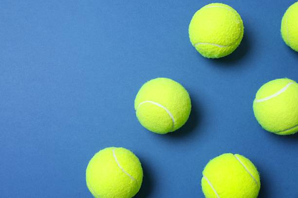 istock Tennis racket and balls on blue background 2249267539