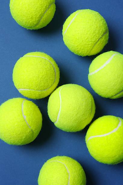 istock Vertical view of tennis balls on blue background 2249267546