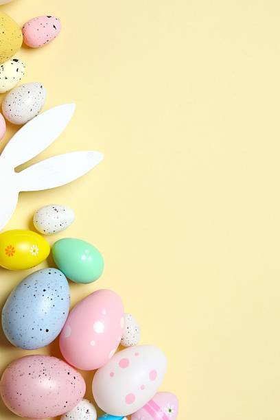 istock Happy Easter. Vertical view of colorful eggs and bunny ears on pastel background, space for text or advertising 2249268165