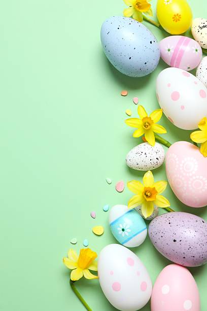 istock Happy Easter. Colorful eggs, yellow flowerson a pastel color background, space for text 2249268174