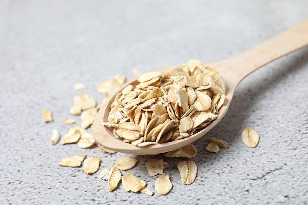 istock Composition with oatmeal flakes on gray background. Cooking breakfast 2249268198