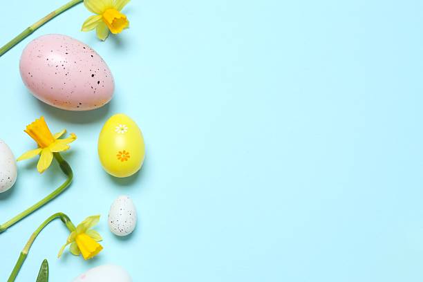 istock Happy Easter. Colorful eggs, yellow flowers on a pastel color background, space for text 2249268925