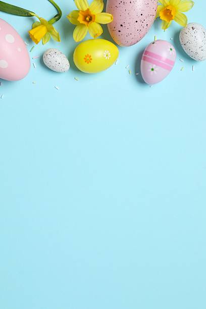 istock Happy Easter. Colorful eggs, yellow flowers on a pastel color background, space for text 2249268935