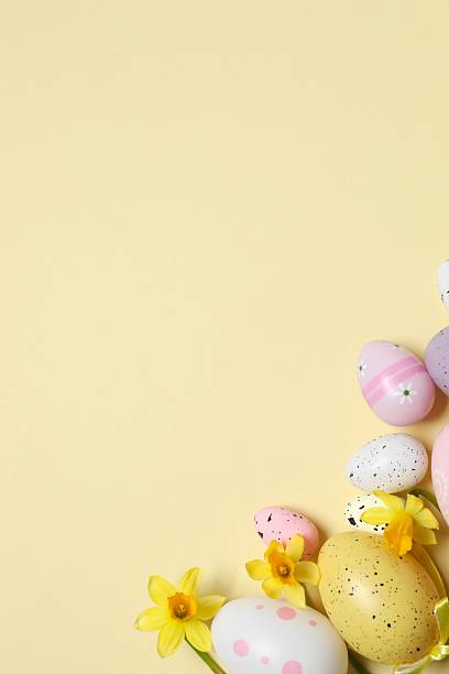 istock Happy Easter. Colorful eggs, yellow flowers on a pastel color background, space for text 2249268949