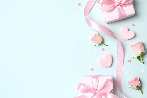 istock Beautiful composition with peony roses, pink hearts and gift boxes on color background 2249269109