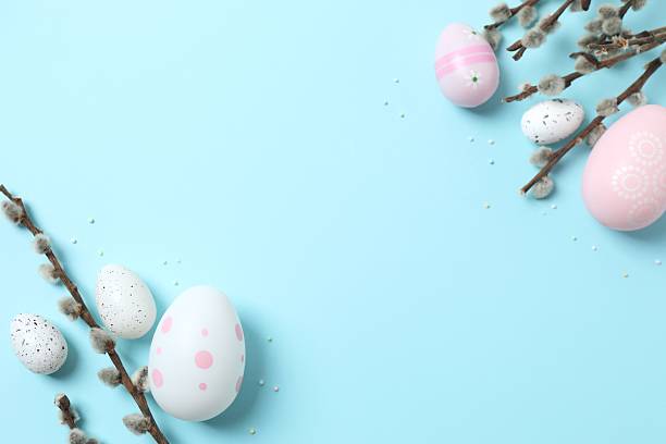 istock Top view of colorful eggs and pussy willow branches on a pastel blue background, space for text or advertising 2249269443