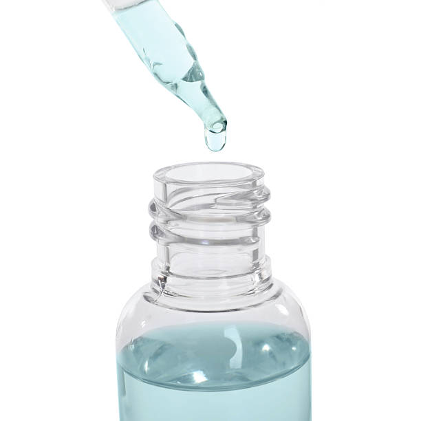 istock Dripping medical drops into bottle on white background 2249274425