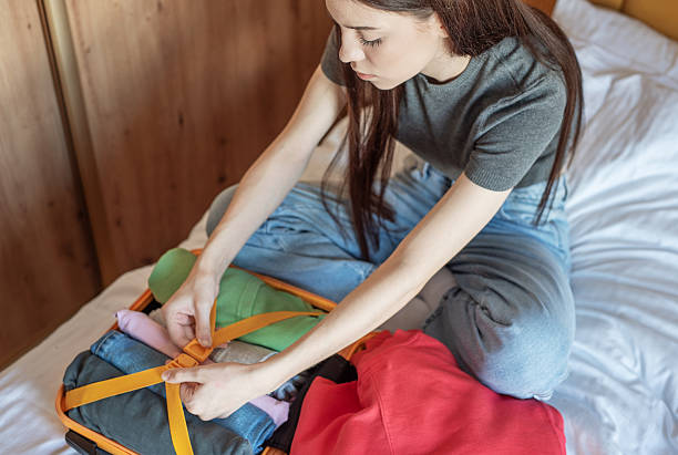 istock Woman packing clothes into suitcase for vacation trip 2249276172