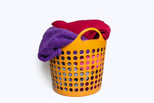 Close-up of a laundry basket full of dirty washing. Isolated on a white background.