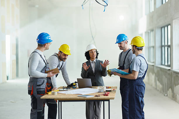 istock Female architect giving instructions to her workers at construction site. 2249280163