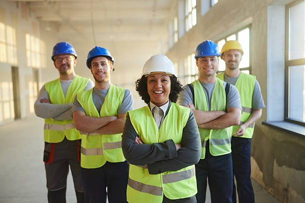 istock Happy project manager in front of her workers at construction site. 2249280288