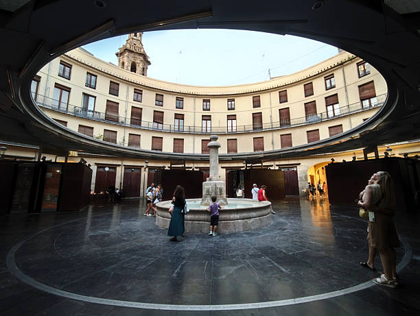 People walking on Plaza Redonda, originally built by Salvador Escrig Melchor in 1840, it stands out as one of Valencia's most distinctive tourist attractions, owed to its unique architecture. Spain.