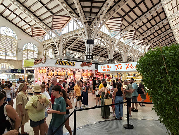 Crowd of tourists walking at the busy Mercado Central, a public market in central Valencia, Spain. It is one of the main works of the Valencian Art Nouveau and one of the largest markets in Europe.