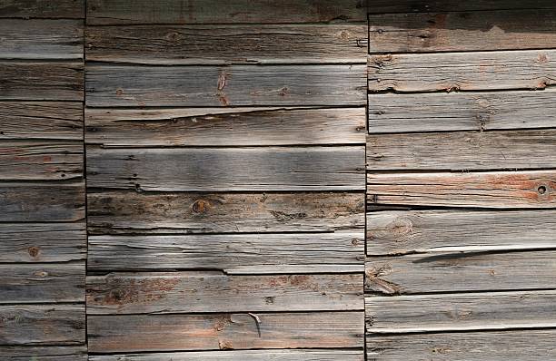 A rustic old wooden wall with weathered planks.