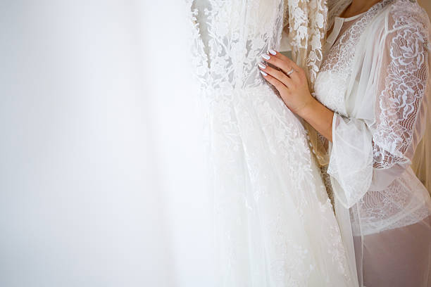 istock the bride holds in her hands a beautiful wedding dress 2249283044