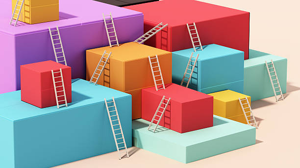 Brightly colored blocks of various shapes and sizes are arranged in an abstract layout, with small ladders leaning against them, suggesting a playful and creative environment.