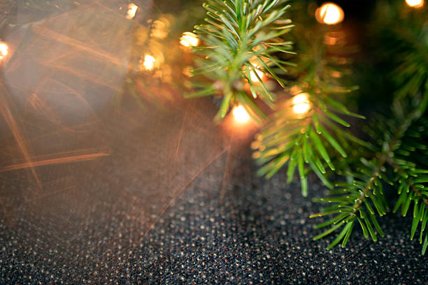 Christmas garland with bokeh lights on a dark fabric background