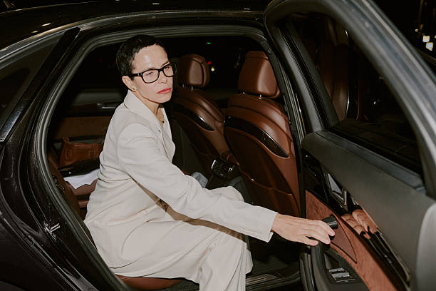 istock Middle Aged Woman Sitting in Car Reaching for Door Handle 2249285488