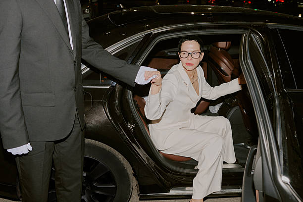 istock Young Adult Woman Exiting Car While Chauffeur Assisting Her 2249285627