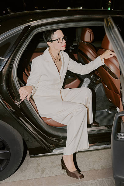 istock Middle Aged Woman Exiting Car during Evening in Urban Setting 2249285668