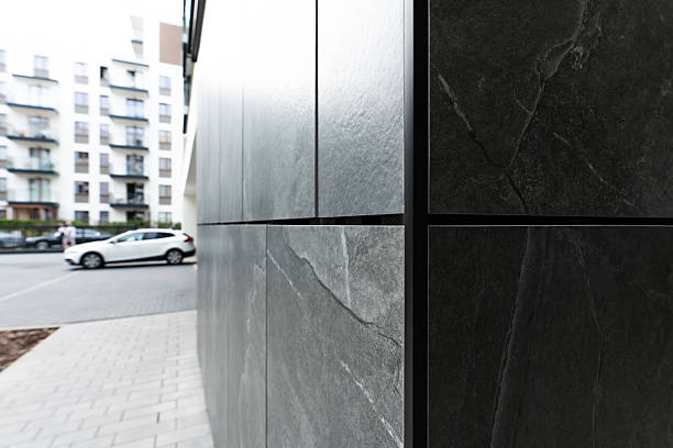 istock Dark Stone Exterior Panels With Natural Texture On Modern Building Facade And Urban Surroundings 2249287138