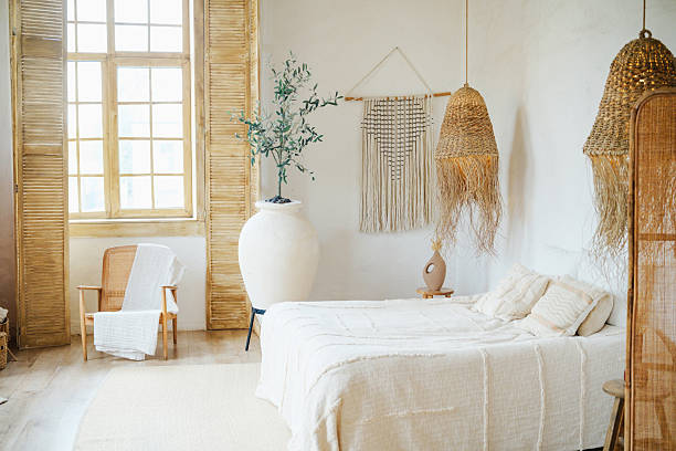 istock Boho bedroom interior with natural textures, rattan furniture, macrame wall hanging and large potted plant. 2249288309