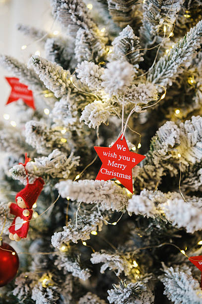 istock Frosted evergreen tree branches decorated with warm fairy lights and festive red ornaments 2249288331