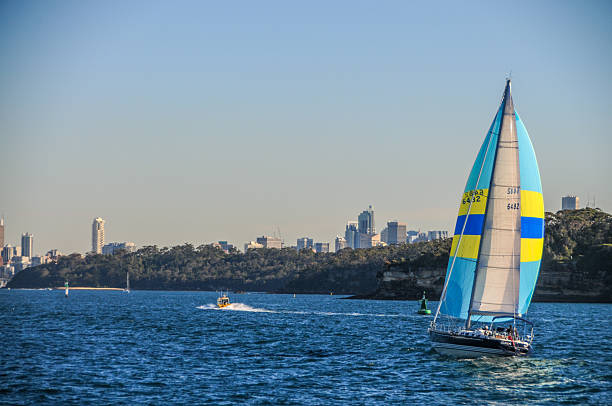 Sydney, Australia - July 25, 2009. Outdoor scene showing a sailboat crossing Sydney harbout on a beatifully sunny afternoon.