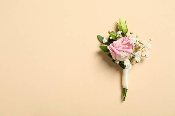 Wedding stuff. Stylish boutonniere on beige background, top view. Space for text