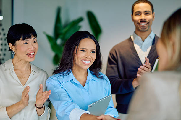 istock Diverse business team celebrating achievement with handshake and applause, collaborating on success in modern office 2249292701