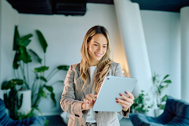 istock Young businesswoman using tablet for remote work, communicating online, or managing business in a modern office 2249293338