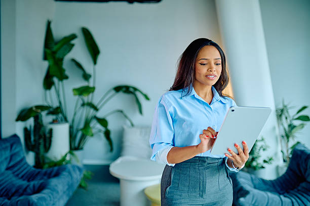 istock Young Black businesswoman standing in modern office, using digital tablet for remote work and corporate communication 2249293355