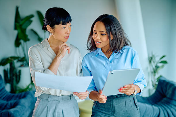 istock Businesswomen discussing documents and digital tablet, collaborating on a project in a modern office 2249293475