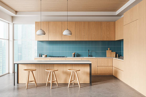 istock Modern kitchen interior with light wood cabinets, blue tile backsplash, and minimalist furnishings in a bright contemporary high-rise apartment. 3D Rendering 2249293771