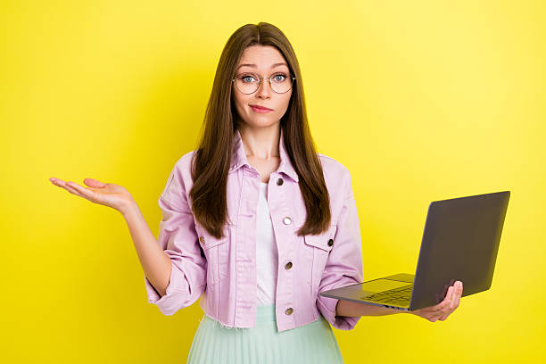 istock Portrait of attractive clueless girl copywriter using laptop studying learning web isolated over bright yellow color background 2249294051
