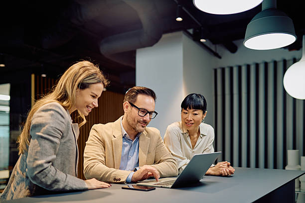 istock Diverse business professionals collaborating on laptop in modern office, discussing strategy and teamwork 2249295906