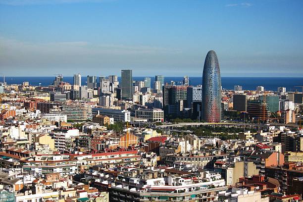 istock Elevated panoramic skyline view of Barcelona, Spain, featuring dense urban blocks, modern skyscrapers, and the Mediterranean Sea horizon on a sunny day 2249296287