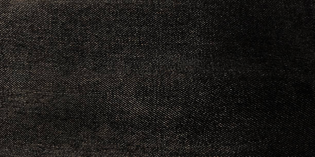 istock Wide, high-resolution texture of dark black or deep gray denim or twill fabric. Features a subtle diagonal weave pattern and minor natural fading, ideal for backgrounds and textile mockups 2249296587