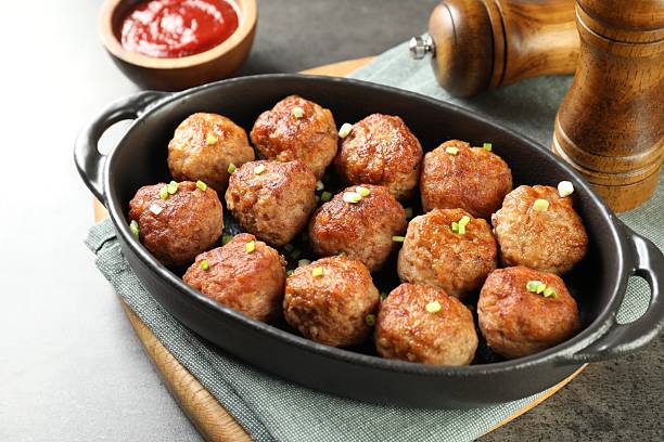 istock Tasty meatballs in baking dish served on grey table 2249296794