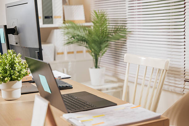 istock home office workspace features modern business desk, laptop computer, monitor setup, documents, green plants, creating productive environment for remote work, digital tasks, comfortable chairs 2249298023