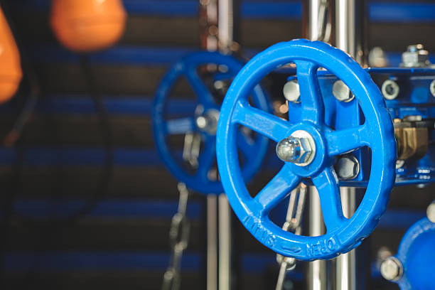 Blue valve with silver bolt.  valve is attached to a pipe in an industrial water supply system.