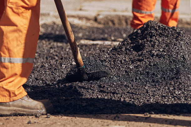 istock Construction worker working on a new asphalt layer on a public street. 2249300327