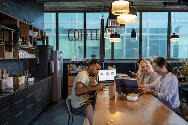 istock Diverse Business Executives Collaborating Over Coffee and Laptops in Office Space 2249300625
