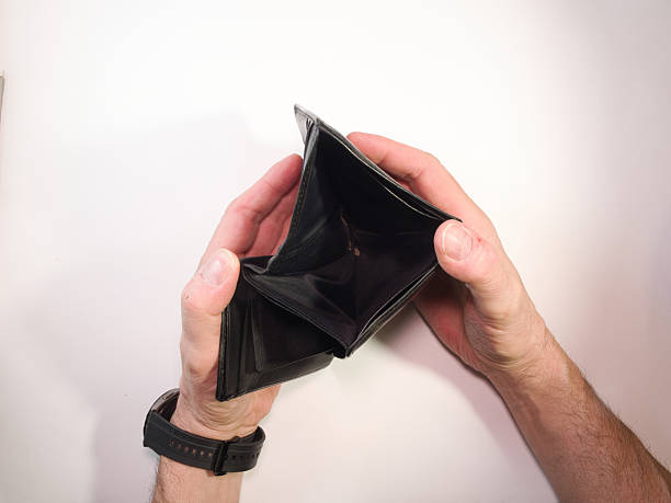 istock Empty Wallet in Hands - Top view of a man's hands opening an empty black wallet on a white background, symbolizing poverty, financial hardship, and economic crisis. 2249300863