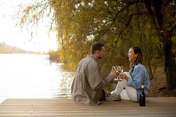 istock Couple enjoying a romantic sunset by the lake while sipping wine and sharing laughter 2249302456