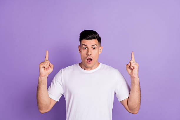 istock Photo of young guy amazed surprised indicate fingers empty space ads decision choose isolated over purple color background 2249302743