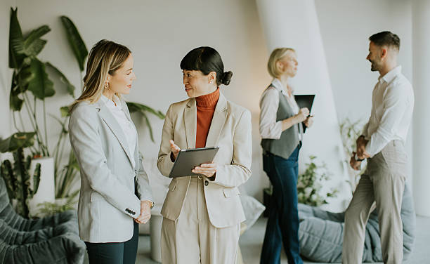 istock Business professionals engage in discussion in a modern office setting 2249303658