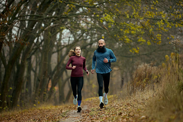 istock Active runners moving forward on forest trail in crisp autumn season 2249305812