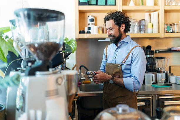 istock Professional Barista with Beard Working Behind Coffee Bar 2249305968
